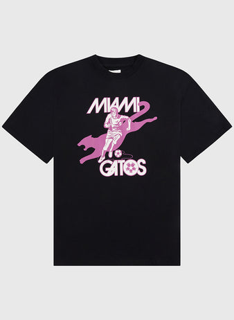 The Ebbets Field Miami Gatos Short Sleeve Graphic T-Shirt features a black base with a pink soccer player, large cat, and ball graphic, plus bold vintage 
