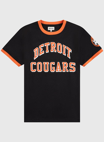 The Detroit Cougars Mesh Soccer Jersey by Ebbets Field is a black short-sleeve jersey with an orange collar and trim, DETROIT COUGARS in bold orange and white on the front, and a left sleeve patch—a vintage soccer classic.