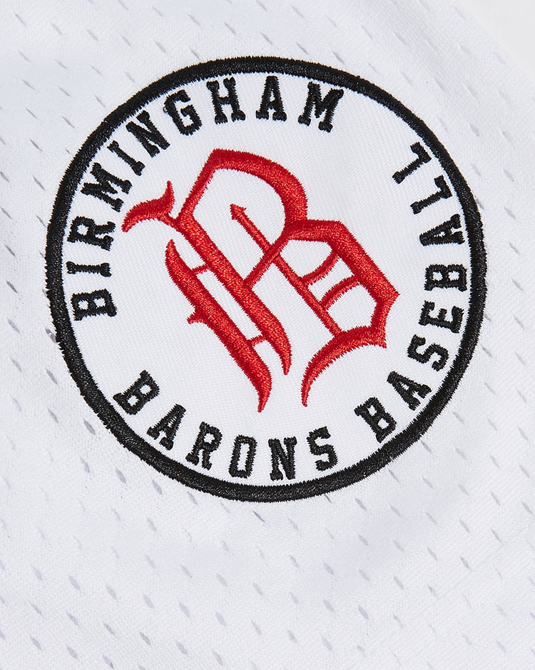 Patch with Birmingham Barons Baseball in black text encircling a red B logo, sewn onto the white perforated mesh fabric of the Ebbets Field Birmingham Barons Frank Thomas Button Up Mesh Jersey.
