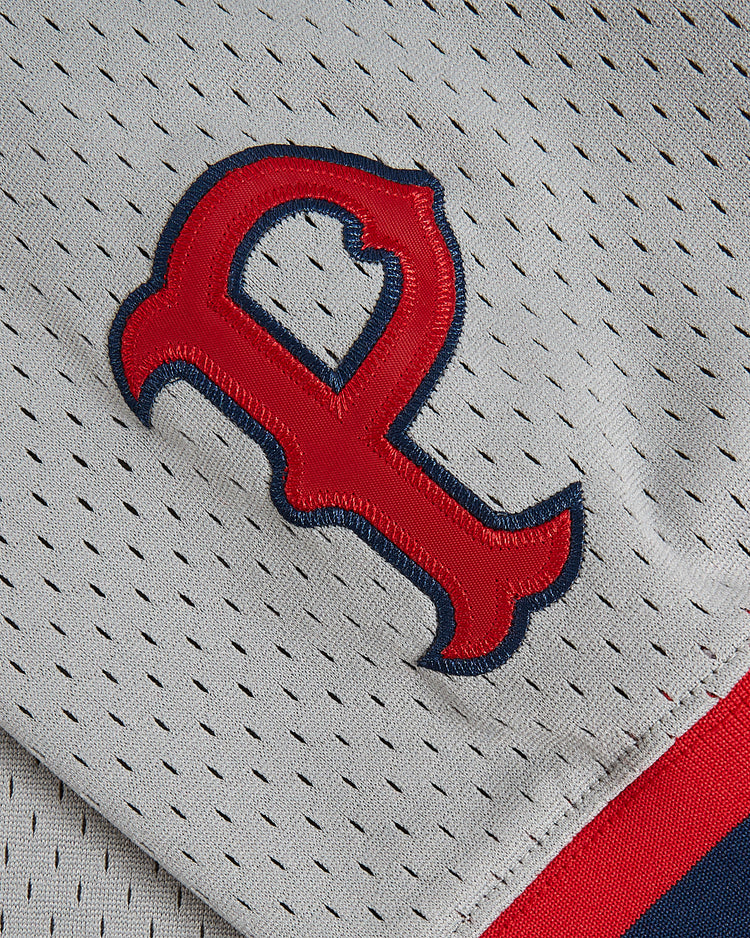 A close-up of the Ebbets Field Wade Boggs Pawtucket Red Sox Mesh V-Neck Jersey showcases its gray mesh fabric with small ventilation holes, a distinctive red and blue 