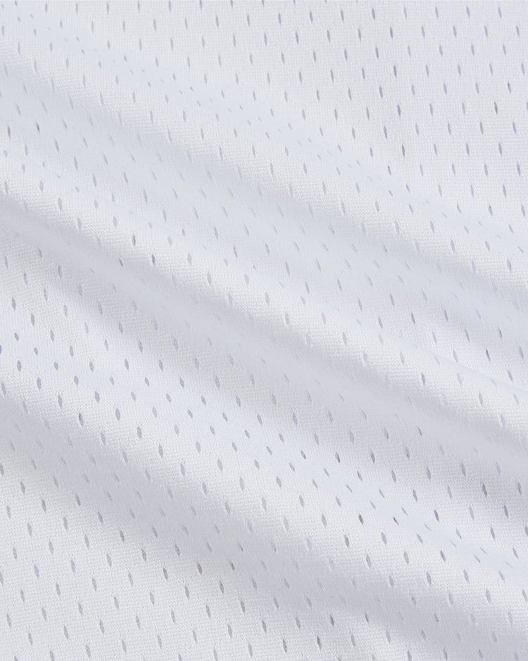 Close-up of the Ebbets Field Randy Johnson El Paso Diablos Button Up Mesh Jersey, featuring white textured mesh fabric with small, evenly spaced gray dots arranged in diagonal lines—reminiscent of classic baseball jerseys. Gentle folds and shadows highlight the jersey’s soft, lightweight, and breathable construction.