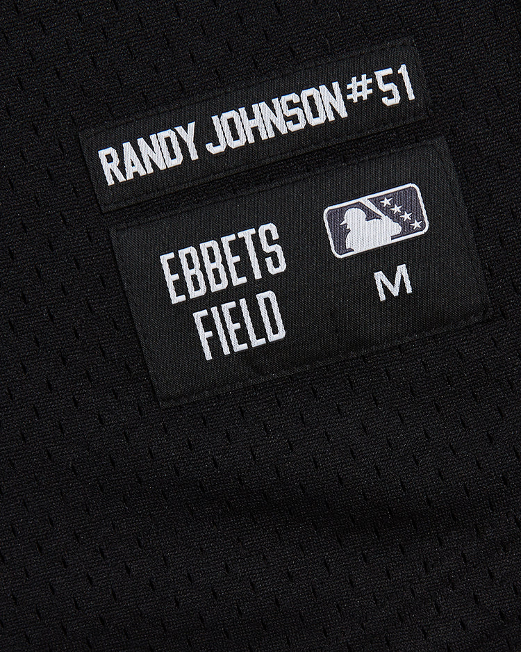 Close-up of the Ebbets Field Randy Johnson Tucson Sidewinders Button Up Mesh Jersey in black, adorned with patches reading 