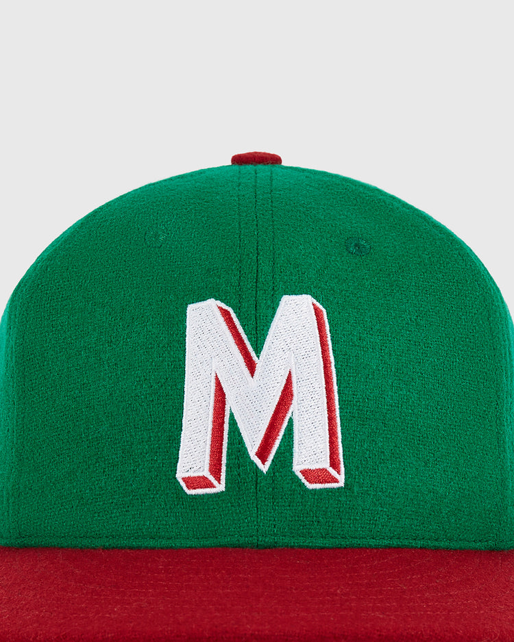 The Ebbets Field Mexico City Reds 1943 Authentic Wool Ballcap is a green cap with a red brim, featuring a prominent white letter 