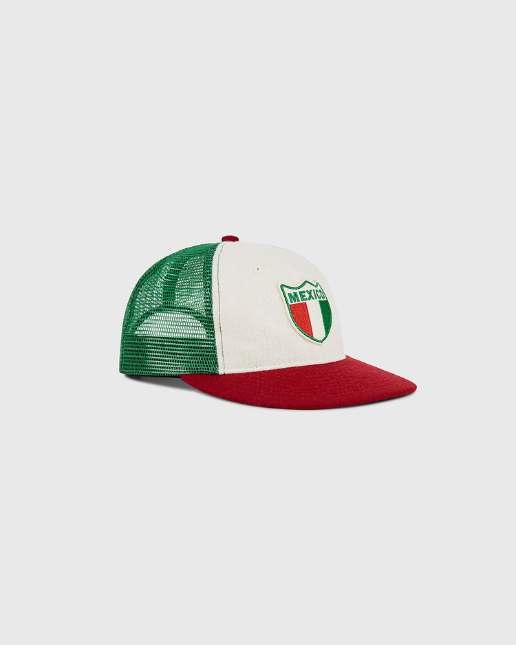 The Ebbets Field Mexico Wool Mesh Trucker Ballcap features a green mesh back, white front panel, and red brim, with a patch that reads 