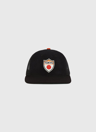 The Ebbets Field Tokyo Giants Wool Mesh Trucker Ballcap is a black vintage baseball cap with a flat brim, featuring a front patch that displays 