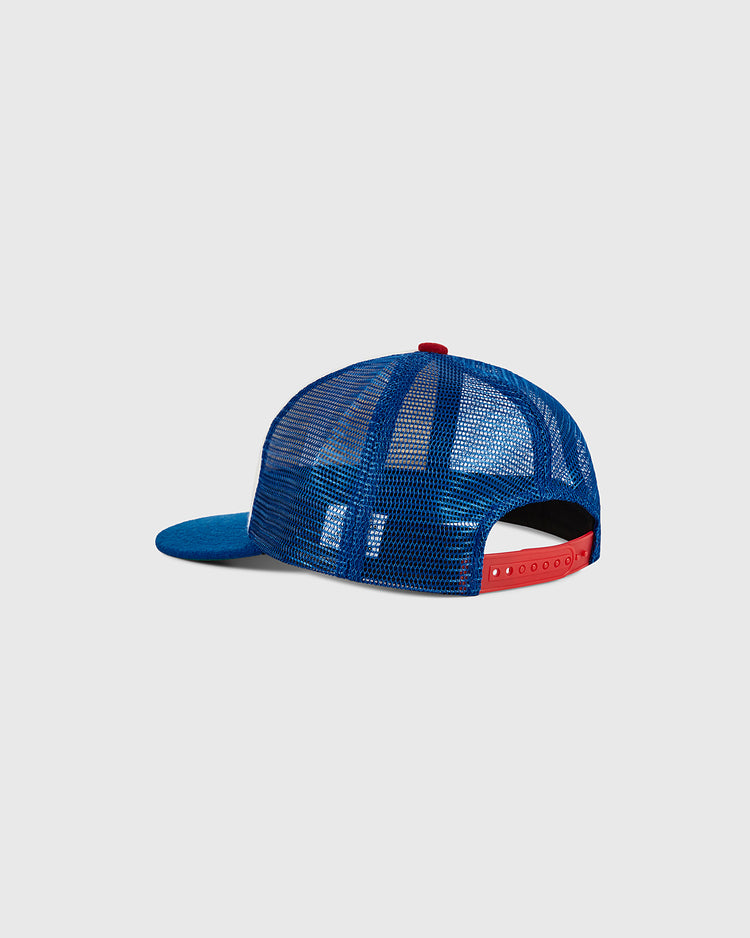 The Santurce Wool Mesh Trucker Ballcap by Ebbets Field, featuring a blue mesh crown and a red adjustable snapback closure, is displayed from the back against a plain light gray background.
