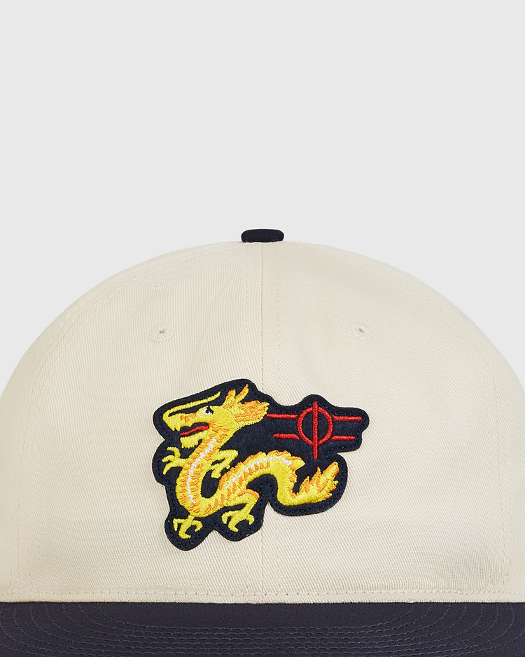 The Chunichi Dragons Cotton Twill Ballcap by Ebbets Field is a beige baseball cap with a dark brim, featuring an embroidered yellow dragon and red symbol on the front for a vintage style inspired by classic Chunichi Dragons ballcaps.