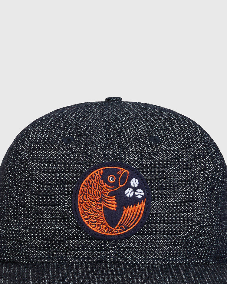 Hiroshima Carp Japanese Indigo Cotton Dobby Ballcap featuring an indigo-dyed textured fabric and a circular patch with an orange koi fish and two white baseballs.