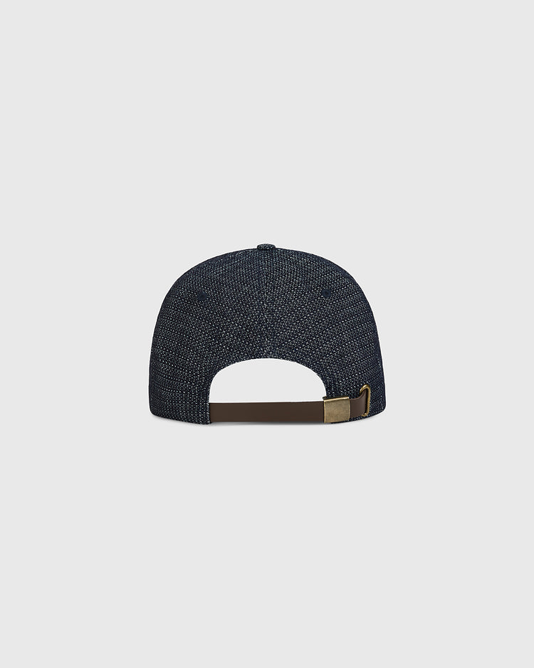 Back view of the Tokyo Giants 1940 Japanese Indigo Dobby Cotton Ballcap, an indigo-dyed, textured baseball cap featuring a brown leather strap and brass buckle closure.