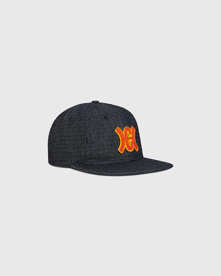 Hiroshima Carp Japanese Indigo Cotton Dobby Ballcap featuring a textured indigo-dyed finish, a flat brim, and an orange and yellow embroidered team logo on the front panel.