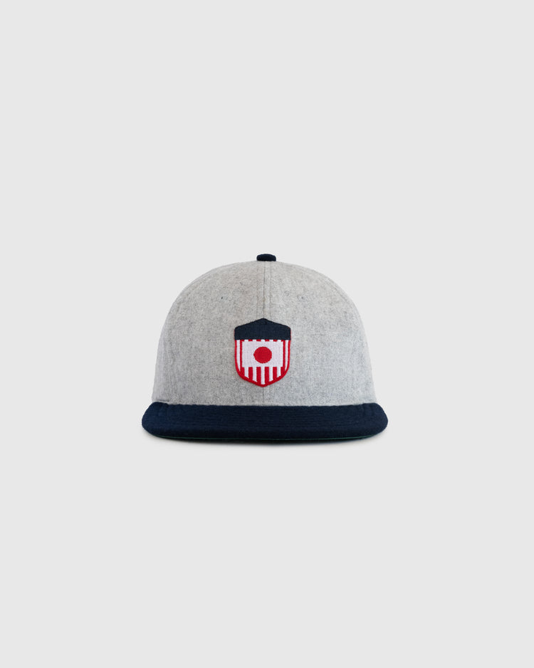 The EFF U.S. Tour of Japan 1922 Authentic Wool Ballcap features a grey crown, dark navy brim, and embroidered red, white, and navy shield emblem on the front, displayed against a plain light background.