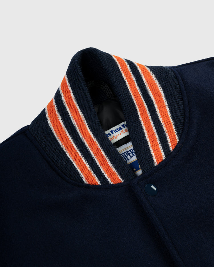 Close-up of the EFF Houston Astros 1965 Authentic All Wool Varsity Jacket, inspired by the Astrodome era. Features orange, white, and navy ribbed collar, snap buttons, and inner garment tags.