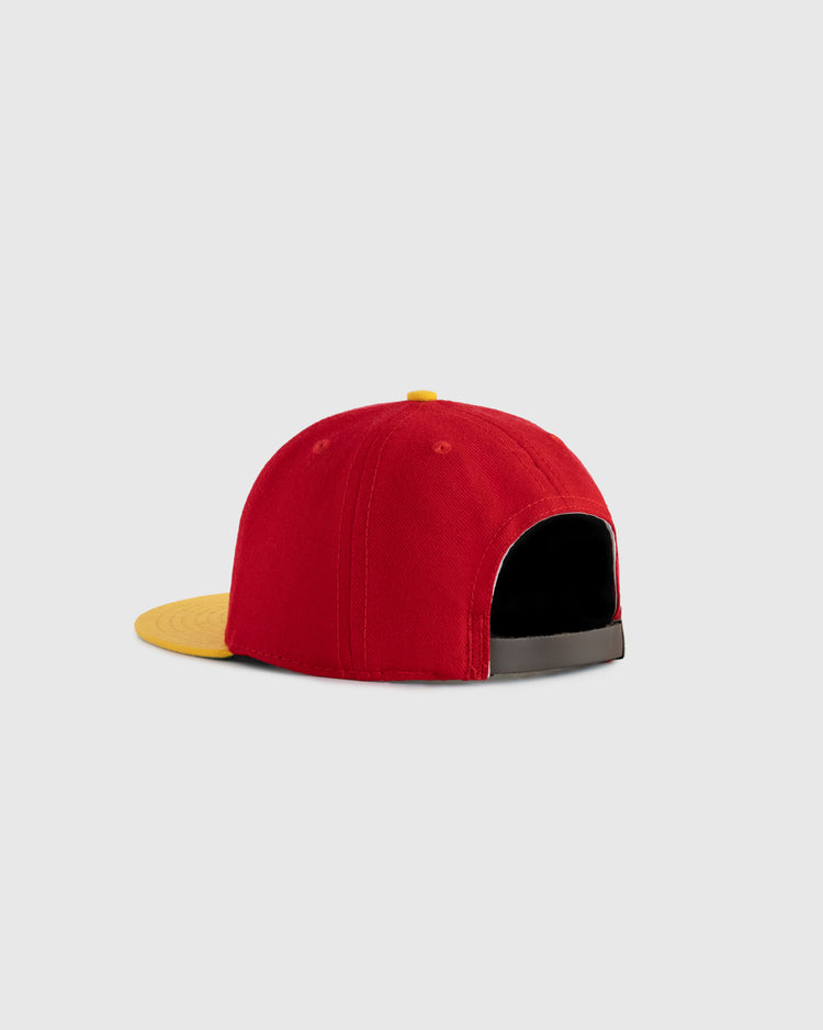 The EFF Hawaii Islanders 1986 Authentic Wool Ballcap is shown from the back, revealing an open adjustable strap and its red wool serge material with a yellow brim, set against a light gray background.