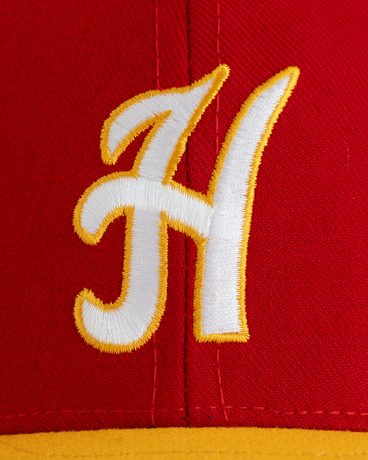The EFF Hawaii Islanders 1986 Authentic Wool Ballcap features a close-up of red wool serge, a large white and yellow embroidered H logo on the front, and a yellow brim.