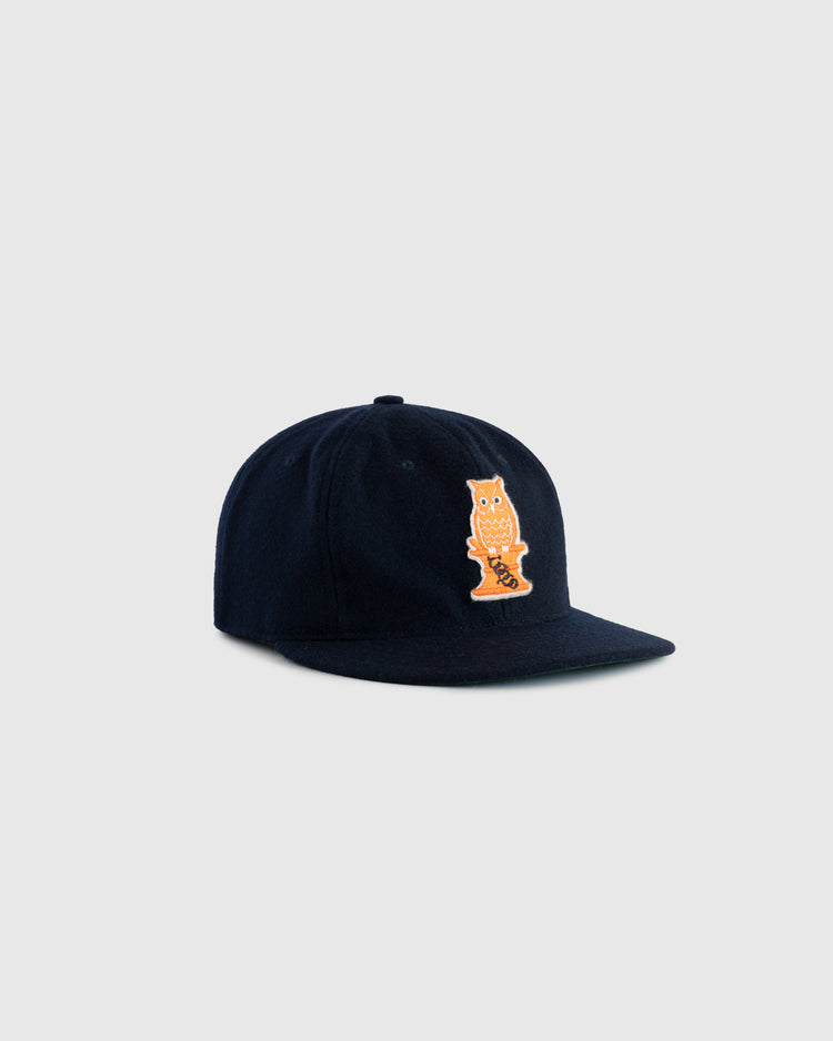 The EFF Owl Drug 1941 Authentic Wool Ballcap is a dark navy flat-brim cap with a bold orange 1941 Owl logo patch, inspired by Bay Area semi-pro baseball, shown on a plain light gray background.