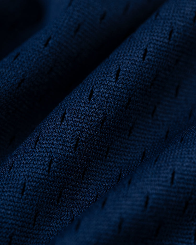Close-up of the EFF Homestead Grays Mesh V-Neck Jersey, featuring dark blue perforated fabric with diagonal lines—a throwback design inspired by baseball history and the legacy of the Homestead Grays.
