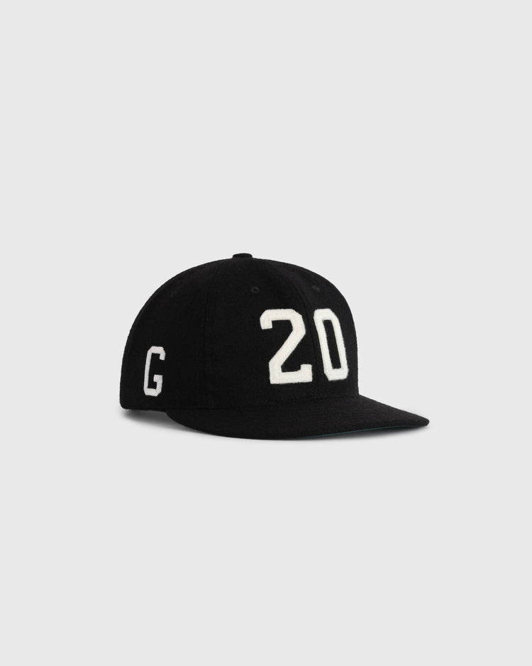 The Ebbets Field Flannels Josh Gibson 1945 Signature Series Wool Ballcap is a black, flat-brim cap with “20” in white on the front and a “G” on the side, honoring Negro Leagues legend Josh Gibson. Shown on a plain light gray background.