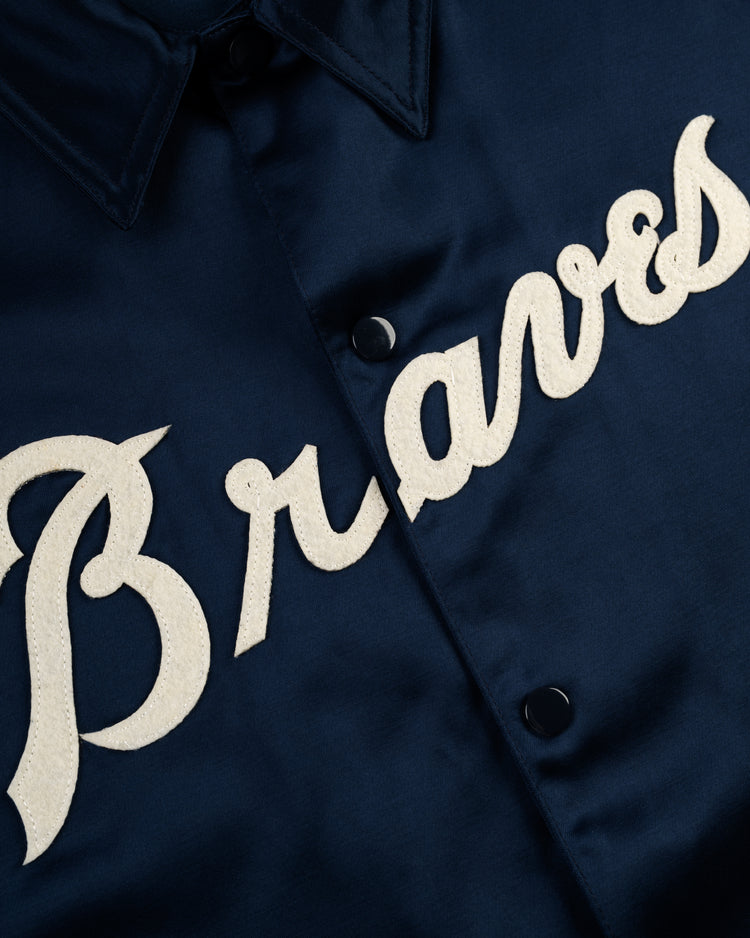 A close-up of the EFF Atlanta Braves 1968 Satin Windbreaker Jacket, featuring large white script Braves lettering across the chest, inspired by the iconic 1968 team logo.
