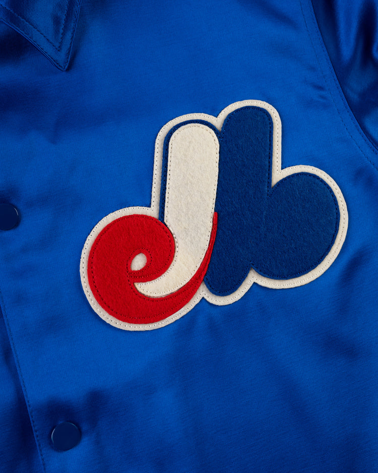 A close-up of the EFF Montreal Expos 1969 Satin Windbreaker, this blue jacket sports the teams iconic red, white, and blue felt logo on the front, cleverly blending the letters e, l, and b.