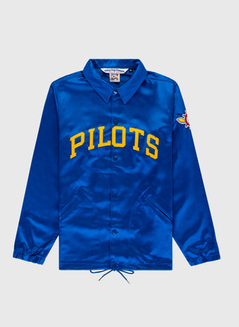 The EFF Seattle Pilots 1969 Satin Windbreaker Jacket features royal blue satin, yellow PILOTS lettering, a colorful pilot patch on the sleeve, plus classic details like a collar, snap buttons, and drawstrings at the hem.