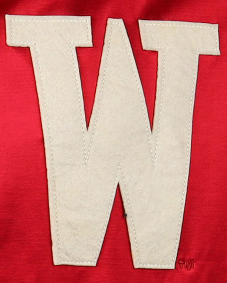A bold white W is stitched on red satin fabric, capturing the classic look of the University of Wisconsin Satin Windbreaker by EFF.