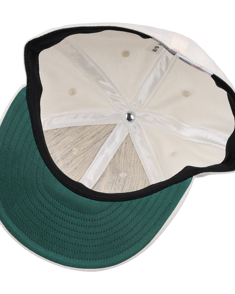 The image shows the inside of an EFF Cream Wool Vintage Ballcap, featuring a green underbrim, black inner band, visible stitching and seams, and a silver button at the crown of this classic cap.