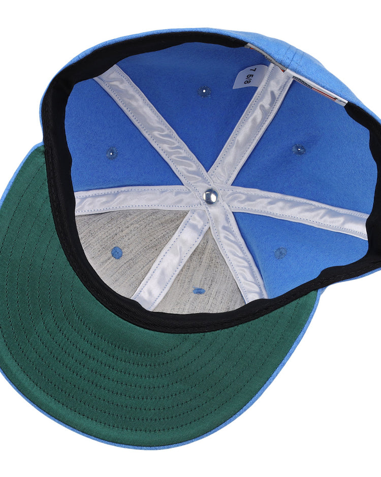 An inside view of the Columbia Blue Wool Vintage Ballcap by EFF reveals its green brim, fabric lining, detailed stitching, and inner size tag—all showcasing classic American-made style.