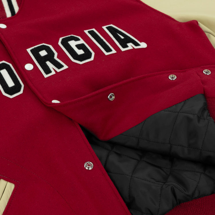 A close-up of the EFF University of Georgia 1966 Authentic Jacket, featuring bold black-and-white GEORGIA lettering and an open front that reveals its black quilted lining.