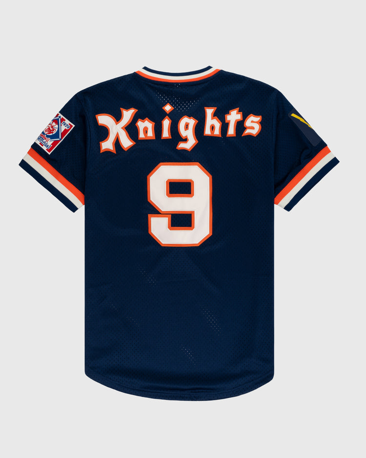 The EFF New York Knights Mesh V-Neck Jersey is navy blue with orange and white trim, stylized Knights font, number 9 on the back, and sleeve patches inspired by Robert Redfords uniform in The Natural.
