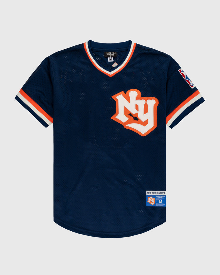 The EFF New York Knights Mesh V-Neck Jersey features a navy blue design with orange and white trim, a large “NY” logo, sleeve patch, and “New York Forever” label—modeled after Robert Redford’s jersey in The Natural.