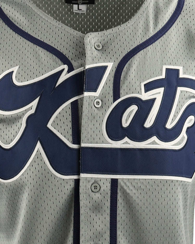 Close-up of the Kansas City Katz EFF DNA Replica Button-Up Mesh Jersey by EFF, featuring gray mesh with navy trim, buttons, and bold Kats script—a tribute to Kansas Citys historic Katz Drugstore and Ban Johnson Baseball League.