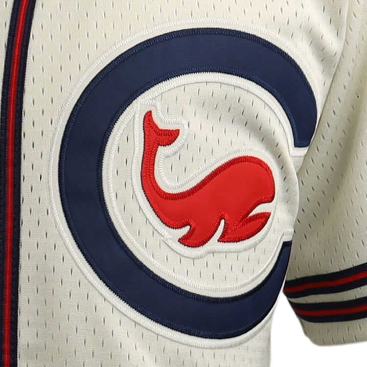 Close-up of the EFF Chicago Whales DNA Replica Button-Up Mesh Jersey, cream-colored with a blue “C” and red cartoon whale logo outlined in white and blue, plus thin vertical perforations and red-blue sleeve stripes.