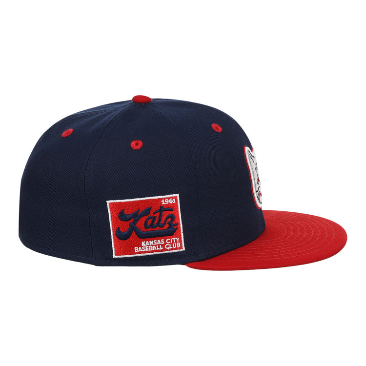 The Kansas City Katz EFF DNA Fitted Ballcap by EFF is a vintage-inspired navy cap with a red brim, featuring a Katz logo patch on the front and a 1961 Katz Kansas City Baseball Club patch on the side.