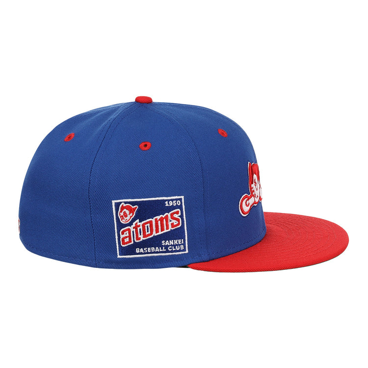 The Sankei Atoms EFF DNA Fitted Ballcap by EFF is a blue vintage-style cap with a red brim, embroidered patches, and a side patch that reads Atoms 1950 SANKEI BASEBALL CLUB with an Atom Boy mascot.