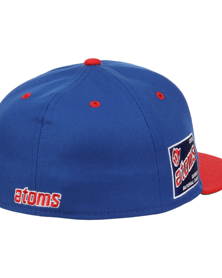 The Sankei Atoms EFF DNA Fitted Ballcap by EFF features blue vintage styling with a red button and brim, atoms embroidered in red and white on the side, an atoms logo patch on the back, and classic Ebbets Field Flannels craftsmanship.