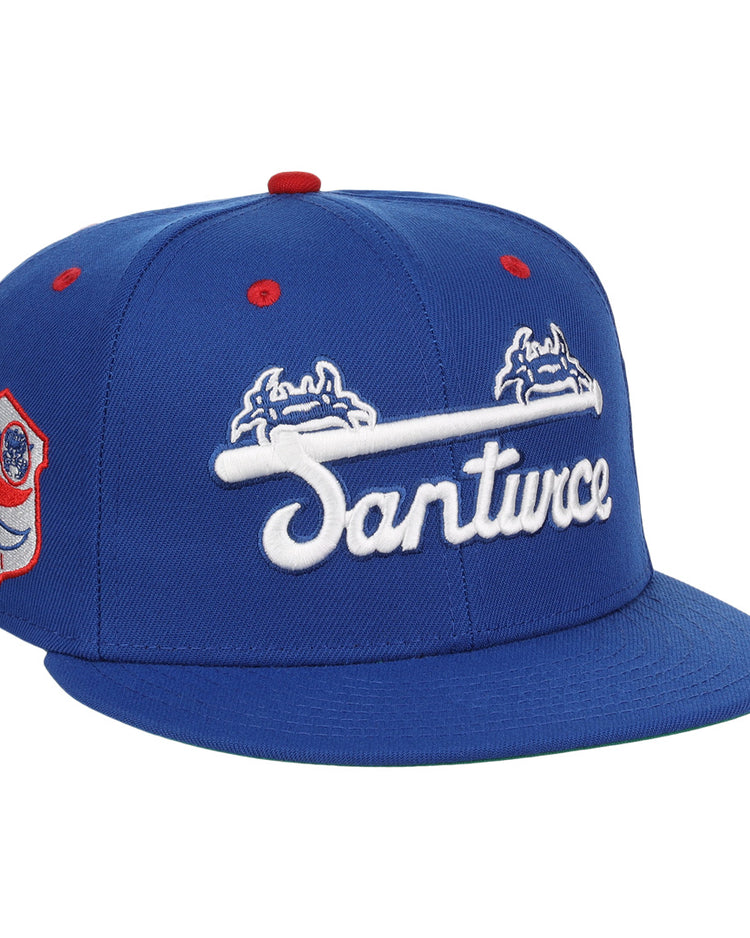 The EFF Santurce Cangrejeros NLB Team Color Fitted Ballcap is a vintage-inspired blue hat with Santurce in white under two blue and white crab logos, plus a Puerto Rican League red and white side patch and red accents on the top and eyelets.