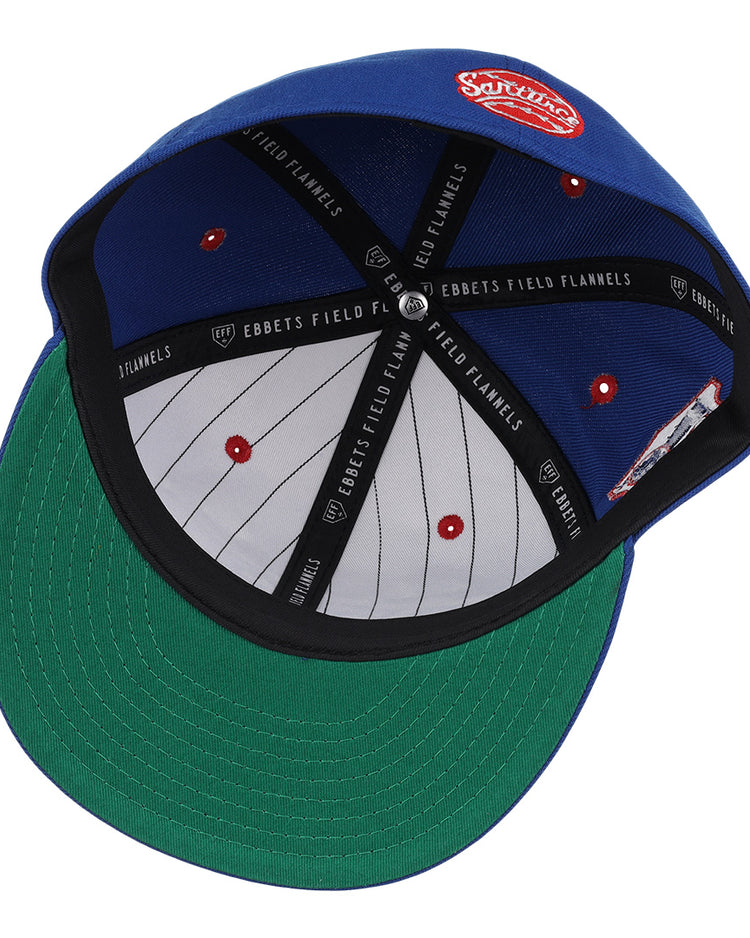 The Santurce Cangrejeros NLB Team Color Fitted Ballcap by EFF features a blue vintage-inspired design, green undervisor, gray crown with red eyelets, black EBBETS FIELD FLANNELS taping, and a red-and-white patch on top.