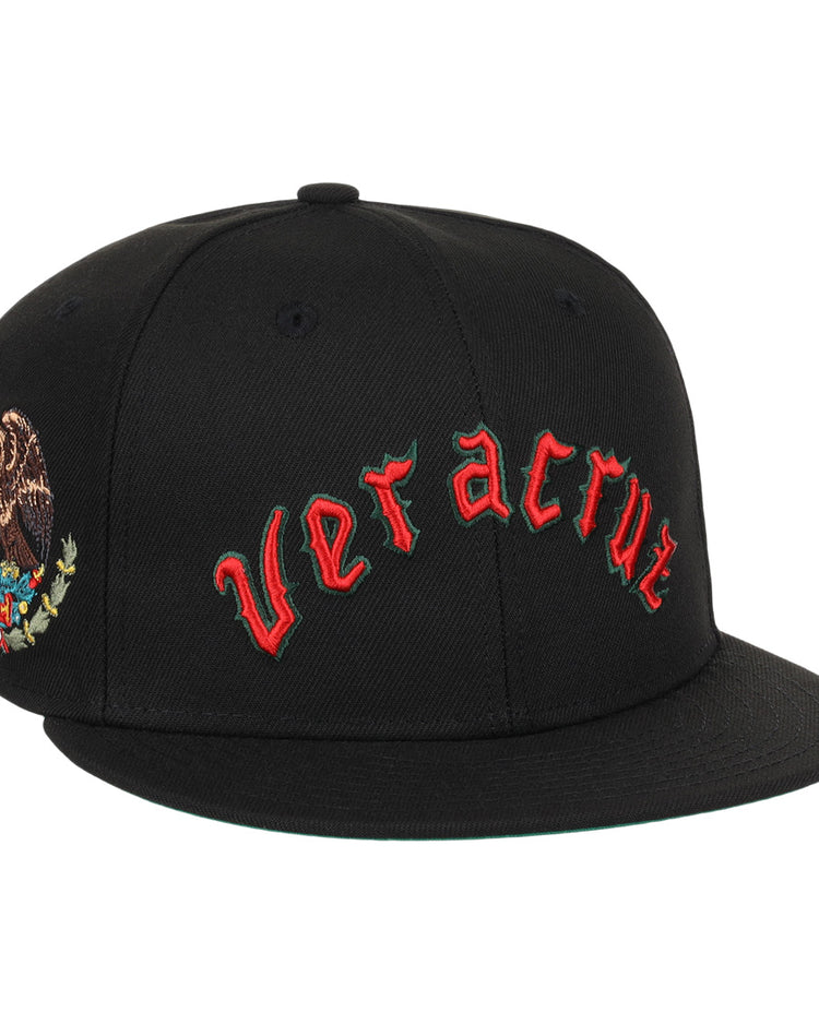 The EFF Veracruz Azules NLB Team Color Fitted Ballcap is a black hat with red gothic lettering on the front and the Mexican emblem on the side—ideal for fans wanting a vintage-inspired Mexican League style.