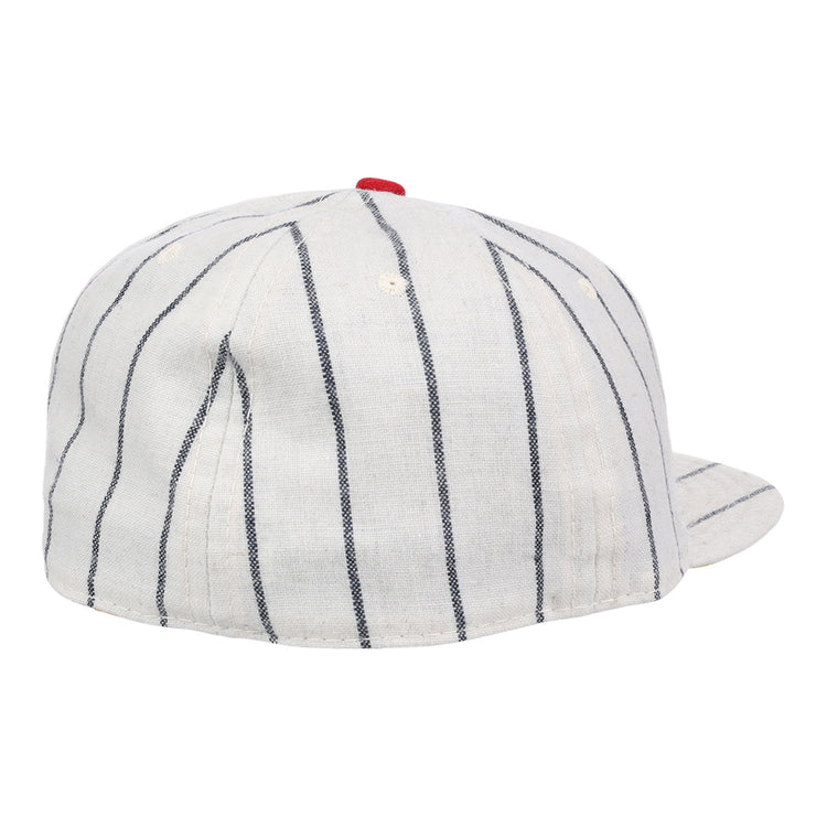 The Limited Edition Newark Peppers 1915 Vintage Ballcap by Ebbets Field Flannels features white fabric with black pinstripes and a small red top button, shown from the back and slightly to the side.