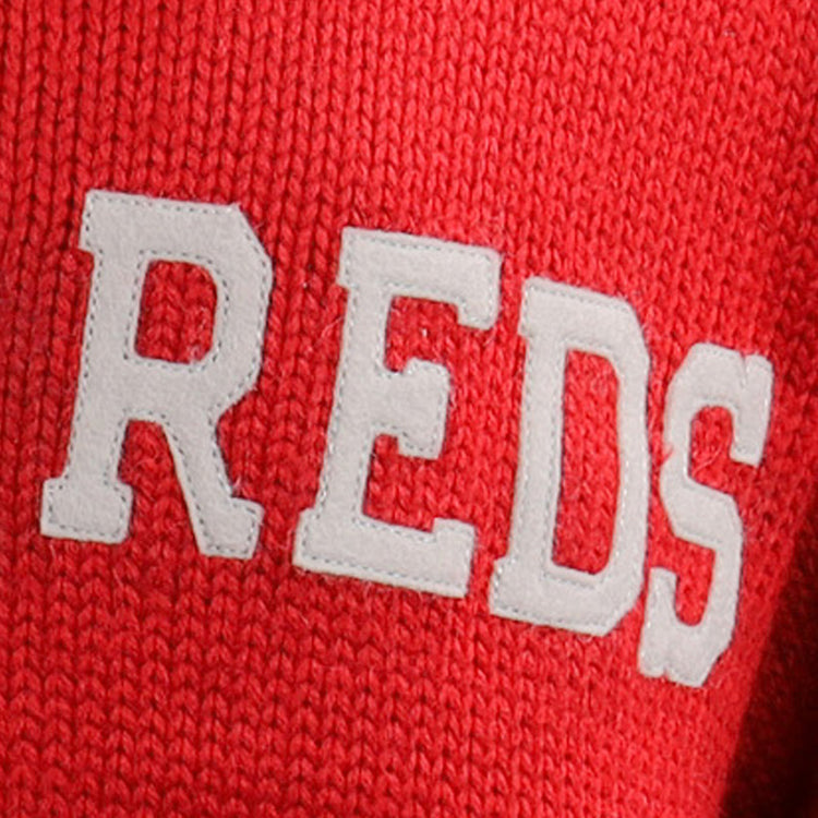 Close-up of the EFF Cincinnati Reds 1919 Shawl Collar Sweater, showing red knit fabric with large, white textured REDS lettering inspired by the classic 1919 design.