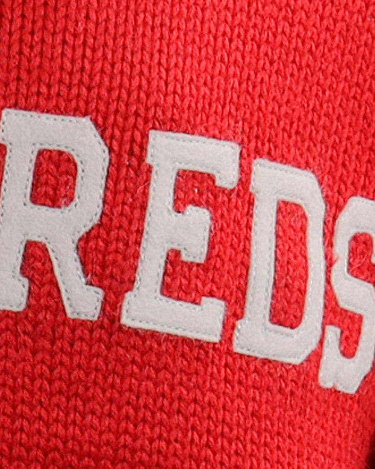 Close-up of the EFF Cincinnati Reds 1919 Shawl Collar Sweater, showing red knit fabric with large, white textured REDS lettering inspired by the classic 1919 design.