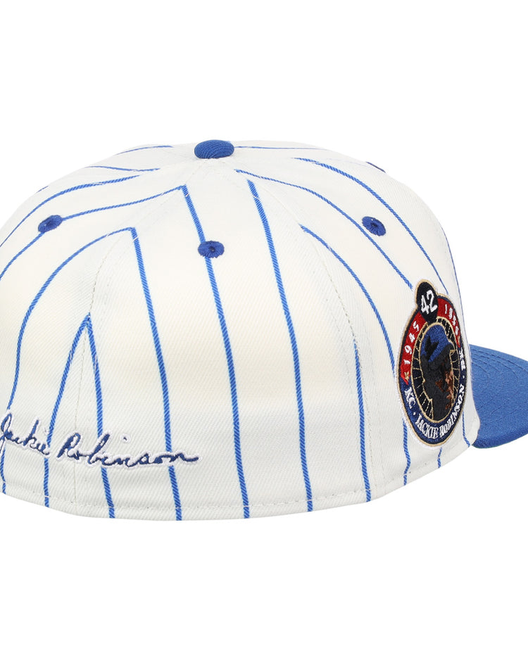 The EFF Jackie Robinson Signature Series Fitted Ballcap - Pinstripe features blue pinstripes, a blue brim, 3D embroidered signature on the side, and a round patch with “42” and Robinson in uniform.