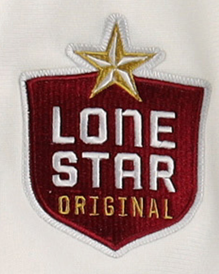 A red, shield-shaped patch with LONE STAR ORIGINAL in white and gold, topped by a gold star, decorates the EFF Beeville Blazers Lone Star Baseball Jersey—great for fans of Corpus Christi or the Blazers.