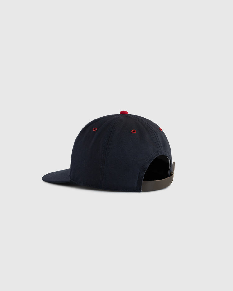 The EFF Portland Beavers Cotton Twill Ballcap is shown from the back in navy, with red eyelets, a red top button, and an adjustable black strap with a metal clasp. This classic cap pops against the light gray background.