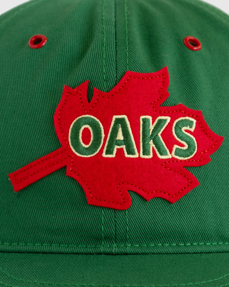 The EFF Oakland Oaks Cotton Twill Ballcap is green with a red maple leaf patch and OAKS embroidered in white and green—a classic tribute to the original ballcap.