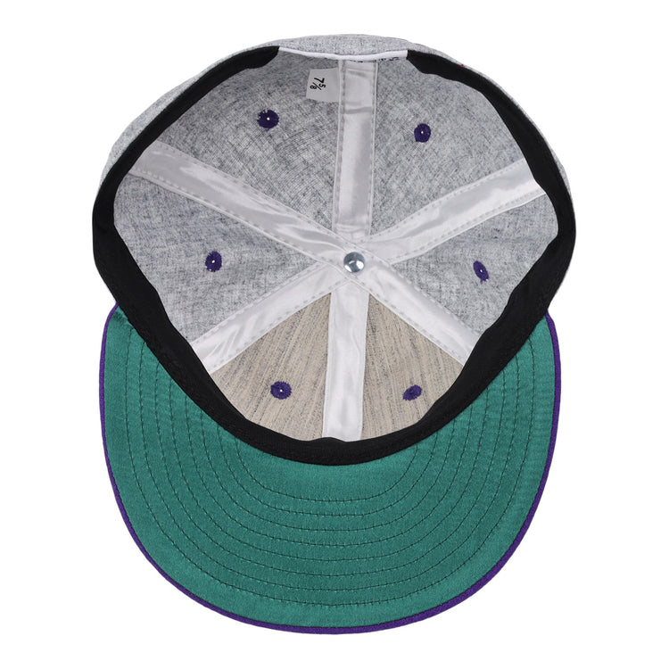 A look inside the EFF Northwestern University Mascot Vintage Ballcap - Gray shows a green underbrim, gray fabric panels, purple eyelets, white seams, and a silver center button.