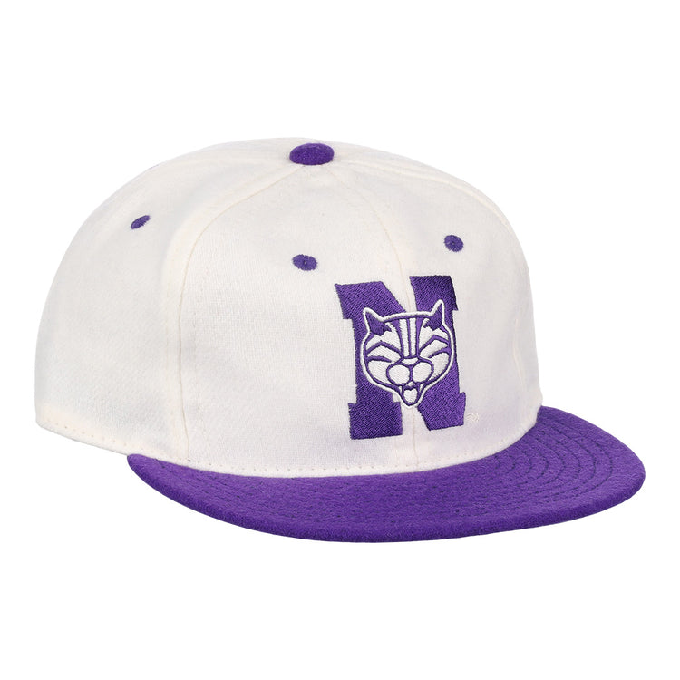 The EFF Northwestern University Vintage Ballcap is a white cap with a purple brim and button, featuring a large purple N with wildcat face embroidery—a classic vintage college baseball hat.