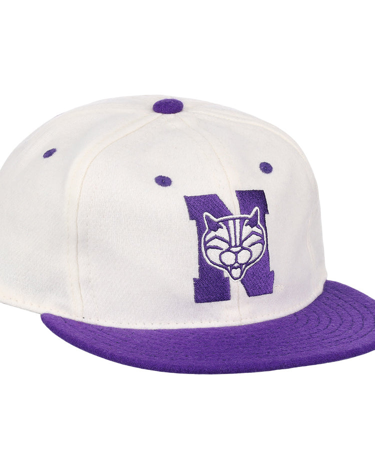 The EFF Northwestern University Vintage Ballcap is a white cap with a purple brim and button, featuring a large purple N with wildcat face embroidery—a classic vintage college baseball hat.
