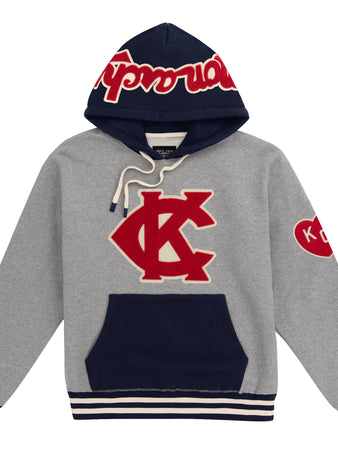 The EFF Kansas City Monarchs Vintage Inspired NLB Colorblock Sweatshirt features a gray and navy design with a large red and white KC Monarchs logo, striped cuffs and hem, a K heart patch on the sleeve, and Supreme in red on the hood.