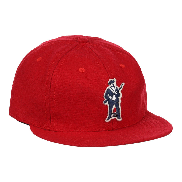 The EFF Greensboro Patriots 1922 Vintage Ballcap is a bright red hat with an embroidered figure in a suit holding a guitar on the front left side.
